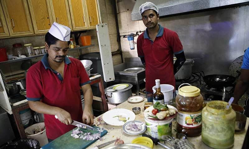 Workers cook food in 'Zaiqa'.— AFP